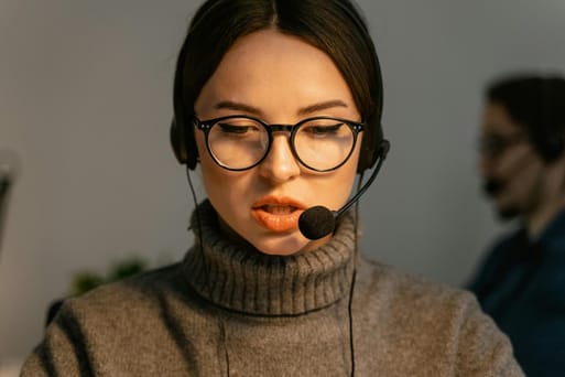 Mulher profissional de atendimento ao cliente concentrada com fone e microfone.